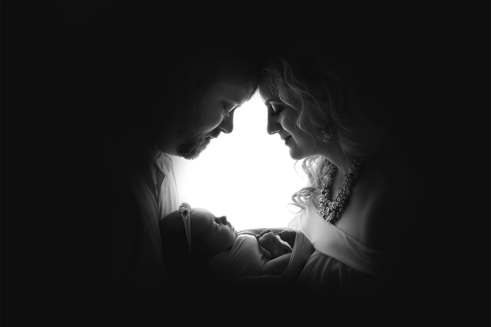 backlit family photo with newborn